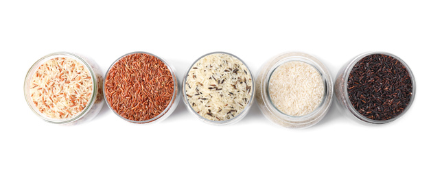 Photo of Brown and polished rice in jars isolated on white, top view