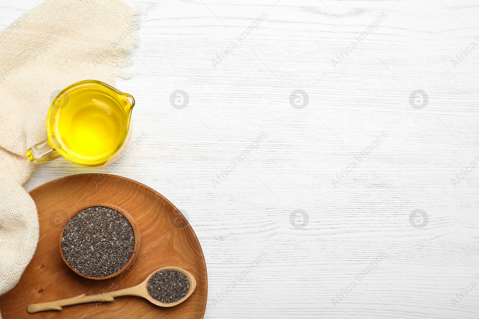 Photo of Flat lay composition with chia seeds and oil in jug on table. Space for text