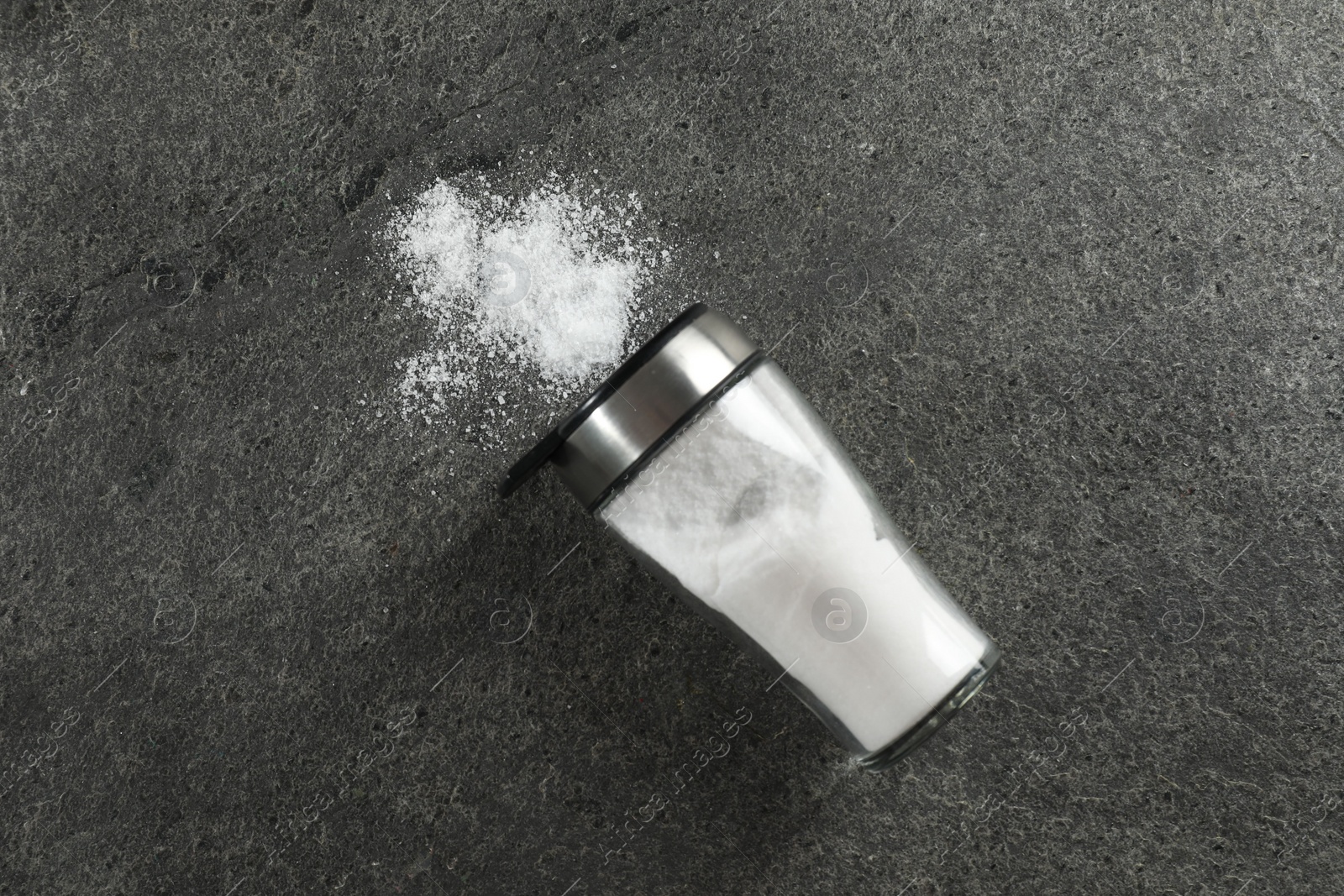 Photo of Salt shaker on grey textured table, top view