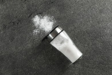 Salt shaker on grey textured table, top view