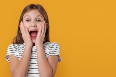Photo of Portrait of surprised girl on yellow background. Space for text