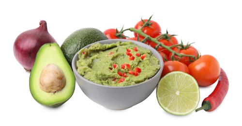 Bowl of delicious guacamole and ingredients isolated on white