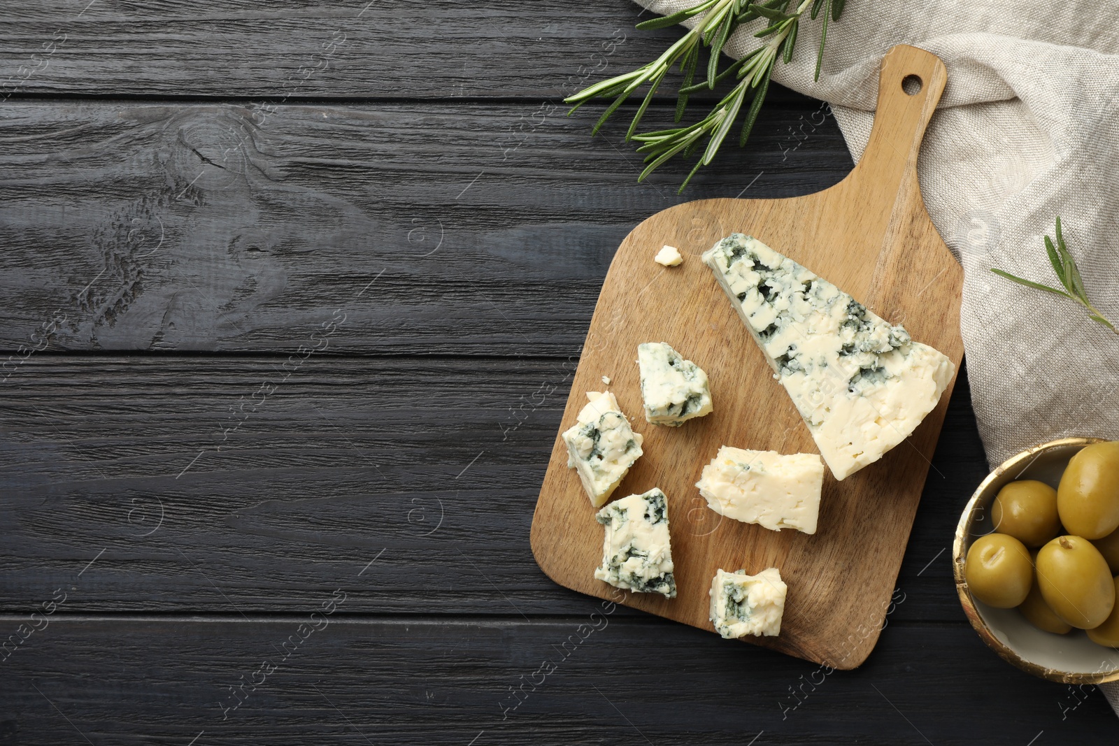 Photo of Flat lay composition with cutting board and products on dark wooden table. Space for text