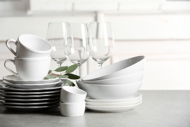 Photo of Set of clean dishes on table against blurred background