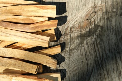 Palo santo sticks on wooden table, top view. Space for text