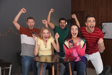 Group of friends celebrating victory at home