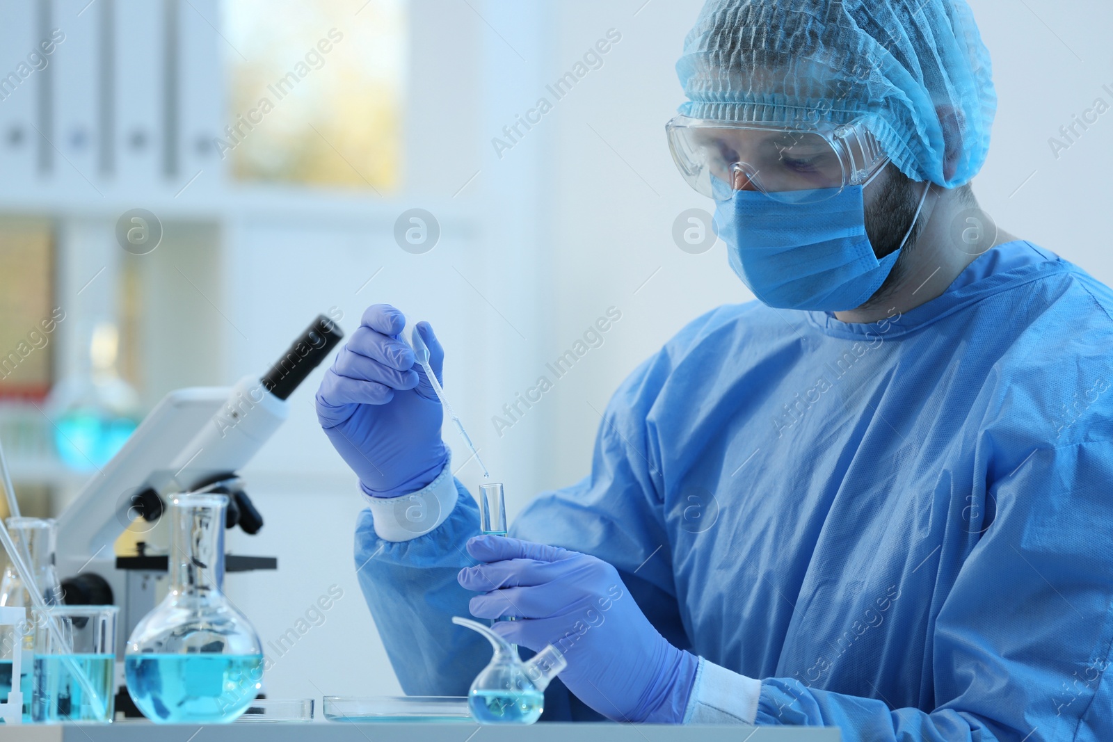 Photo of Scientist dripping sample into test tube in laboratory. Medical research