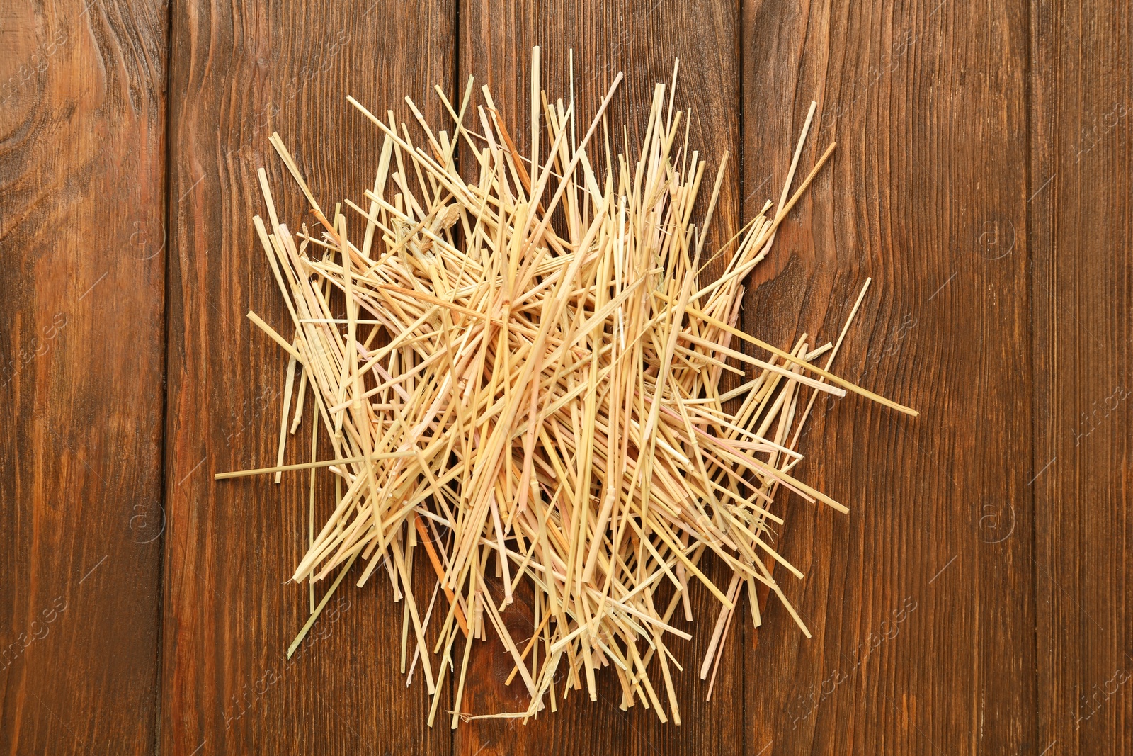 Photo of Dried hay on wooden background, top view