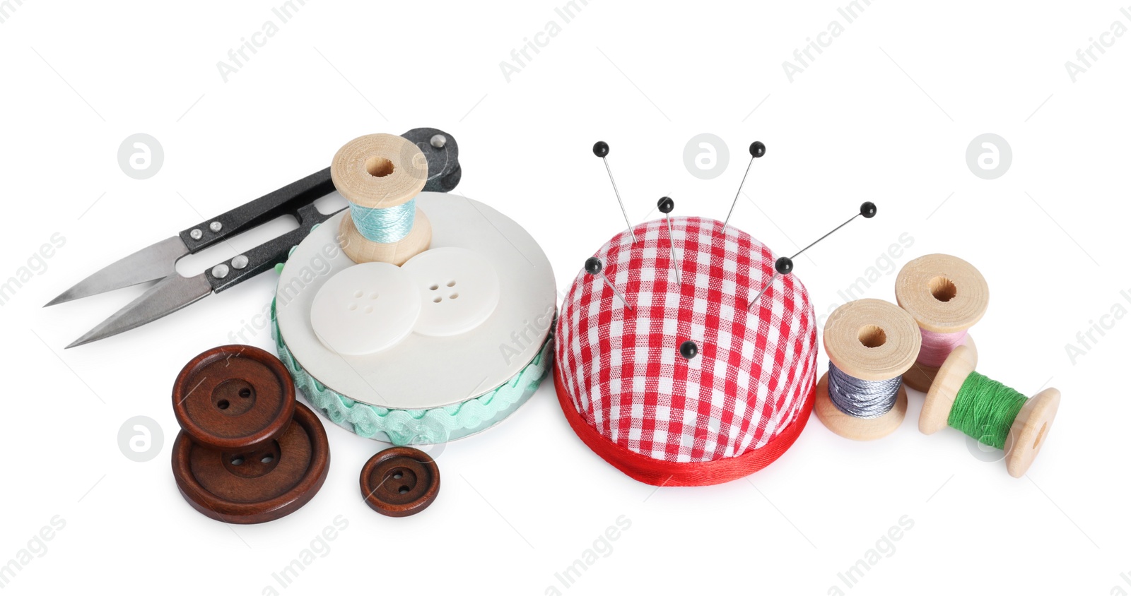 Photo of Pincushion, pins and other sewing tools isolated on white