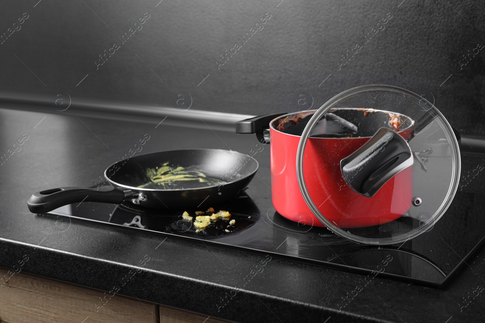 Photo of Dirty pot and frying pan on cooktop in kitchen