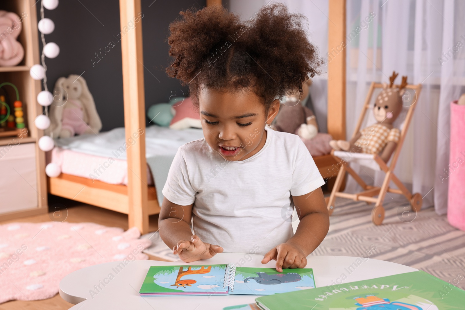 Photo of African American girl reading book at home