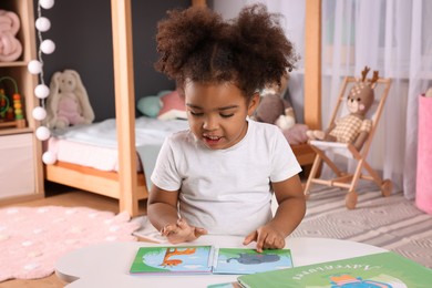 African American girl reading book at home