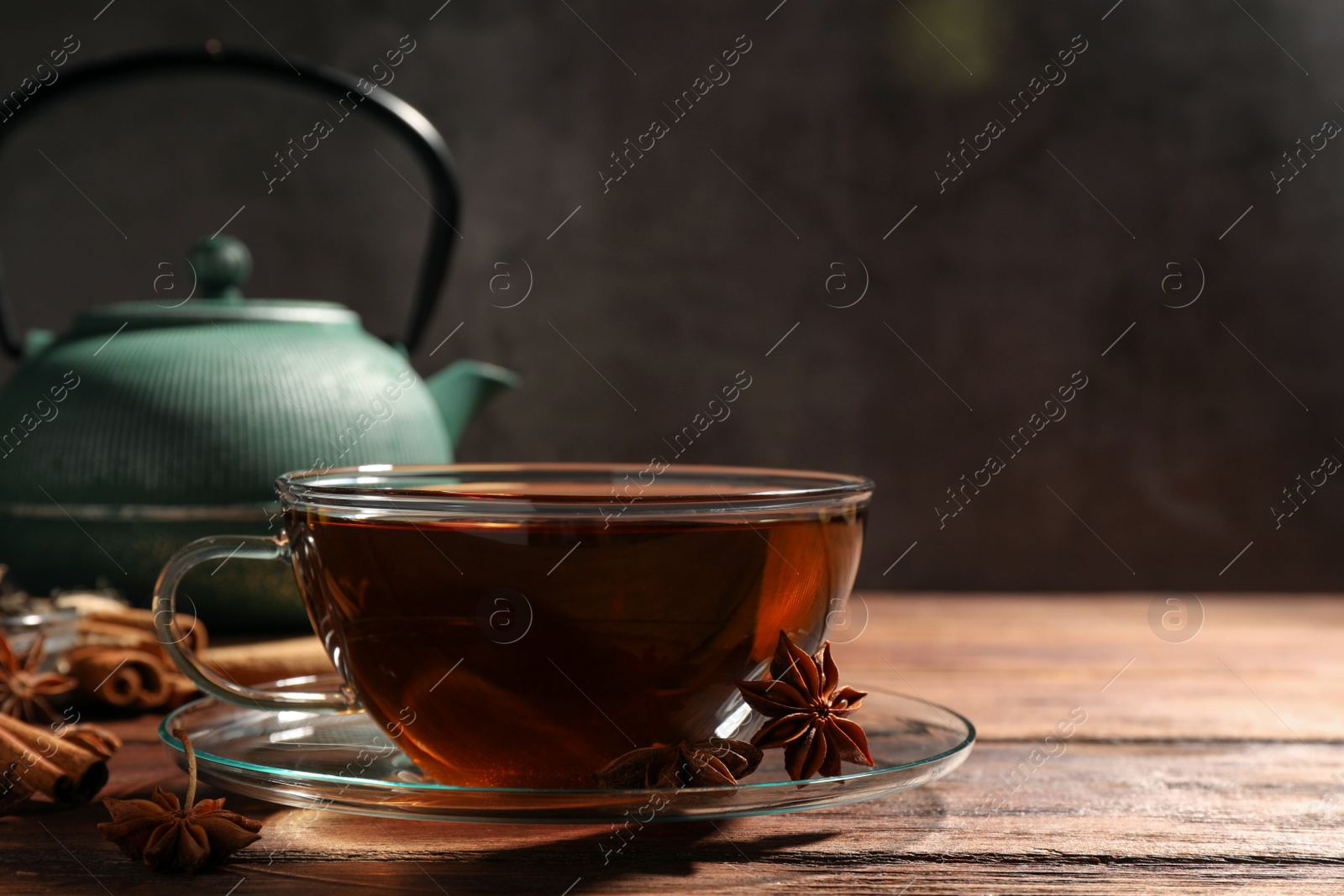 Photo of Aromatic tea with anise stars on wooden table. Space for text