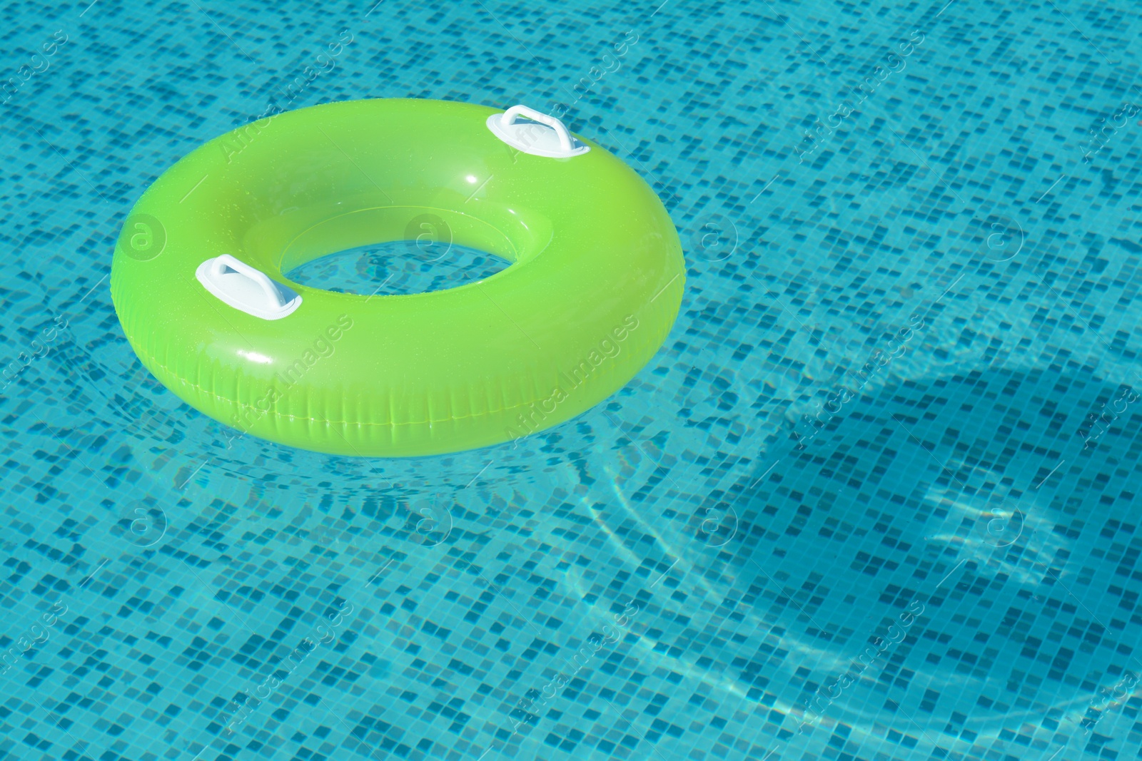 Photo of Light green inflatable ring floating in swimming pool. space for text