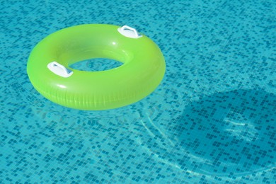Photo of Light green inflatable ring floating in swimming pool. space for text