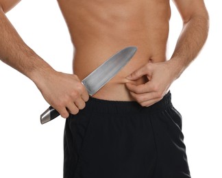 Photo of Fit man with knife on white background, closeup. Weight loss surgery