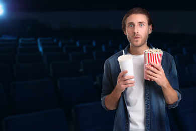 Image of Emotional man with popcorn and beverage in cinema, space for text