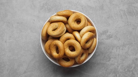 Photo of Bowl of tasty dry bagels (sushki) on grey table, top view