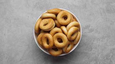 Bowl of tasty dry bagels (sushki) on grey table, top view