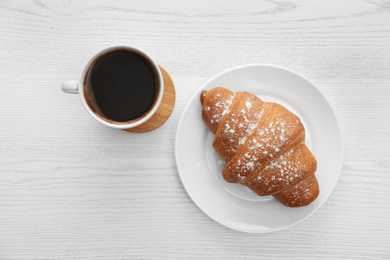 Photo of Delicious morning coffee and croissant on white wooden table, flat lay