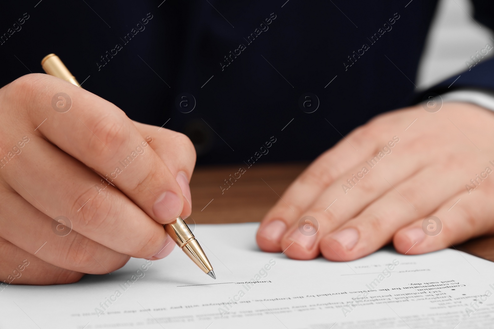 Photo of Man signing document at table, closeup view