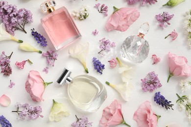 Luxury perfumes and floral decor on white background, flat lay