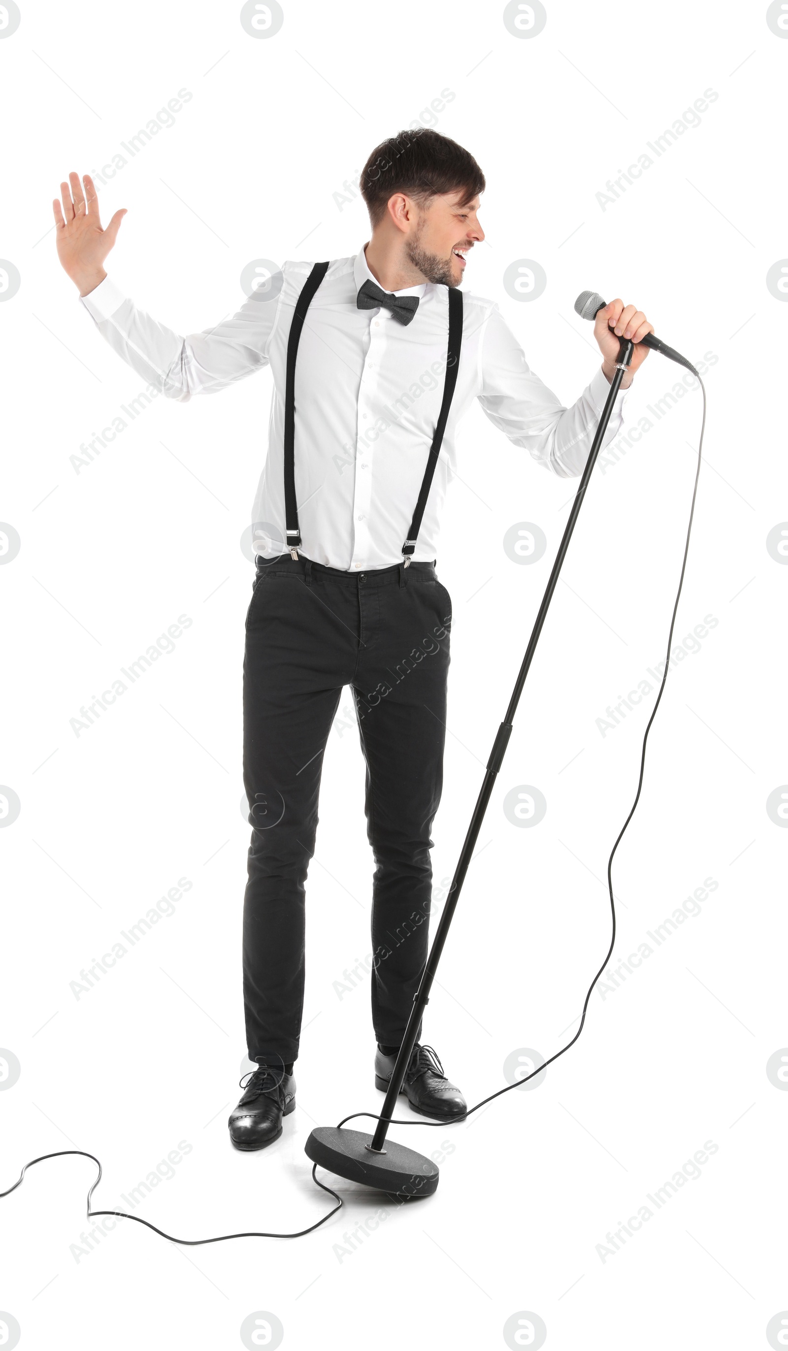 Photo of Handsome man in formal clothes singing with microphone on white background