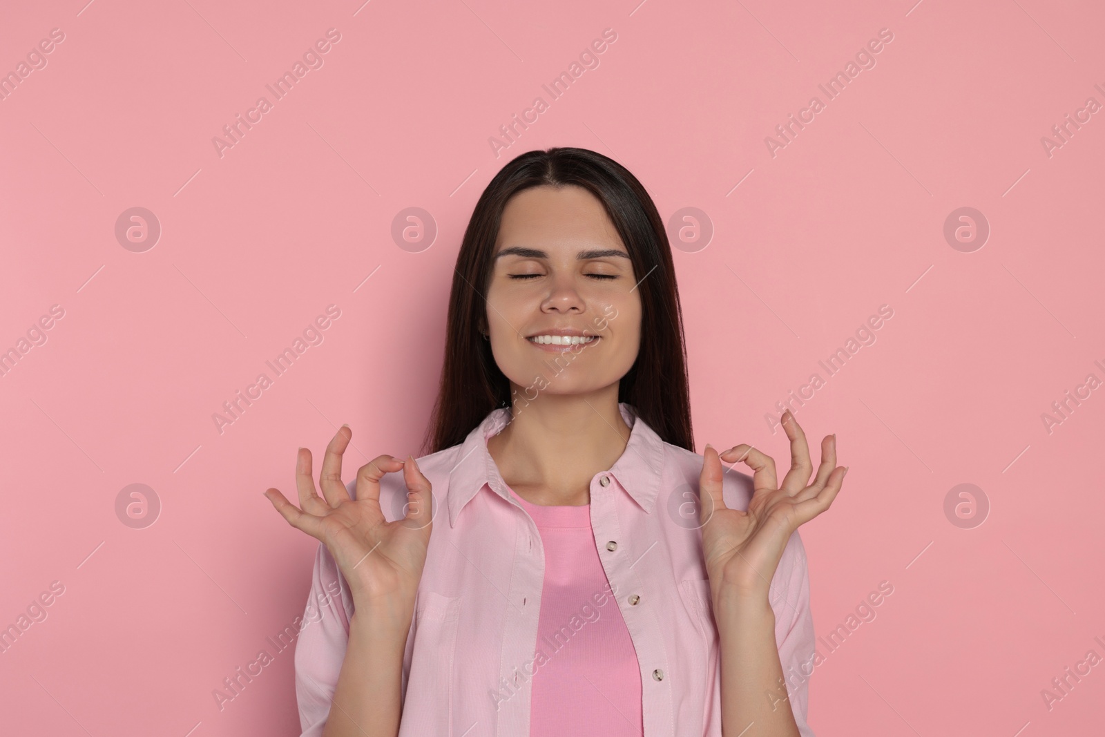 Photo of Young woman meditating on pink background. Zen concept