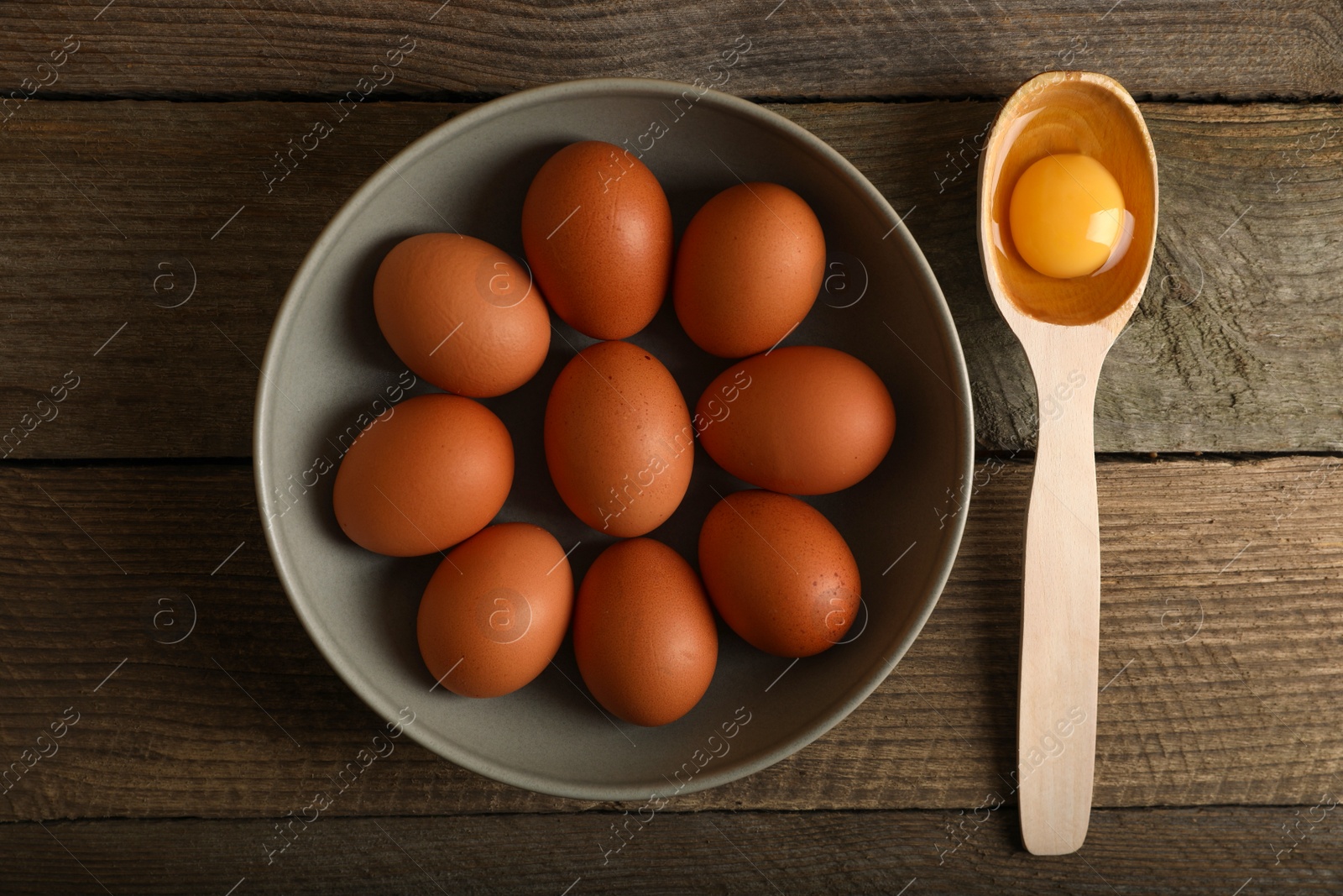 Photo of Raw chicken eggs on wooden table, flat lay