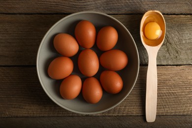 Raw chicken eggs on wooden table, flat lay