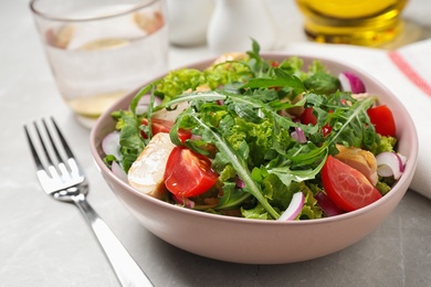 Photo of Delicious salad with chicken, arugula and tomatoes on light table, closeup
