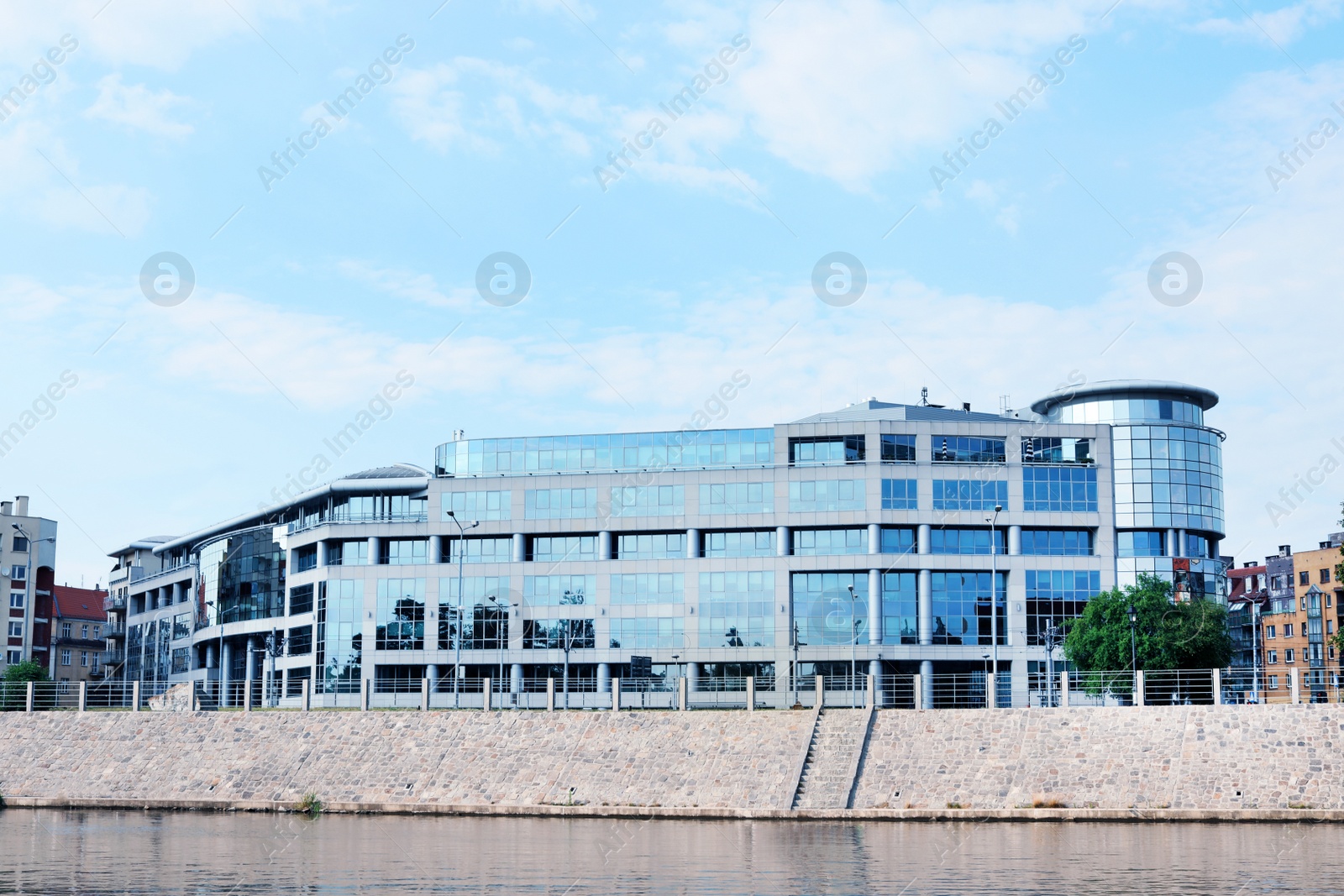 Photo of Building with tinted windows near river. Modern architectural design