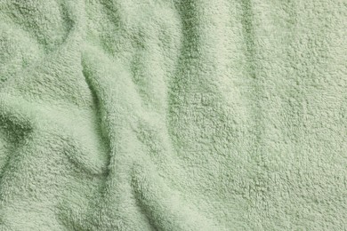 Photo of Soft crumpled pale olive towel as background, top view