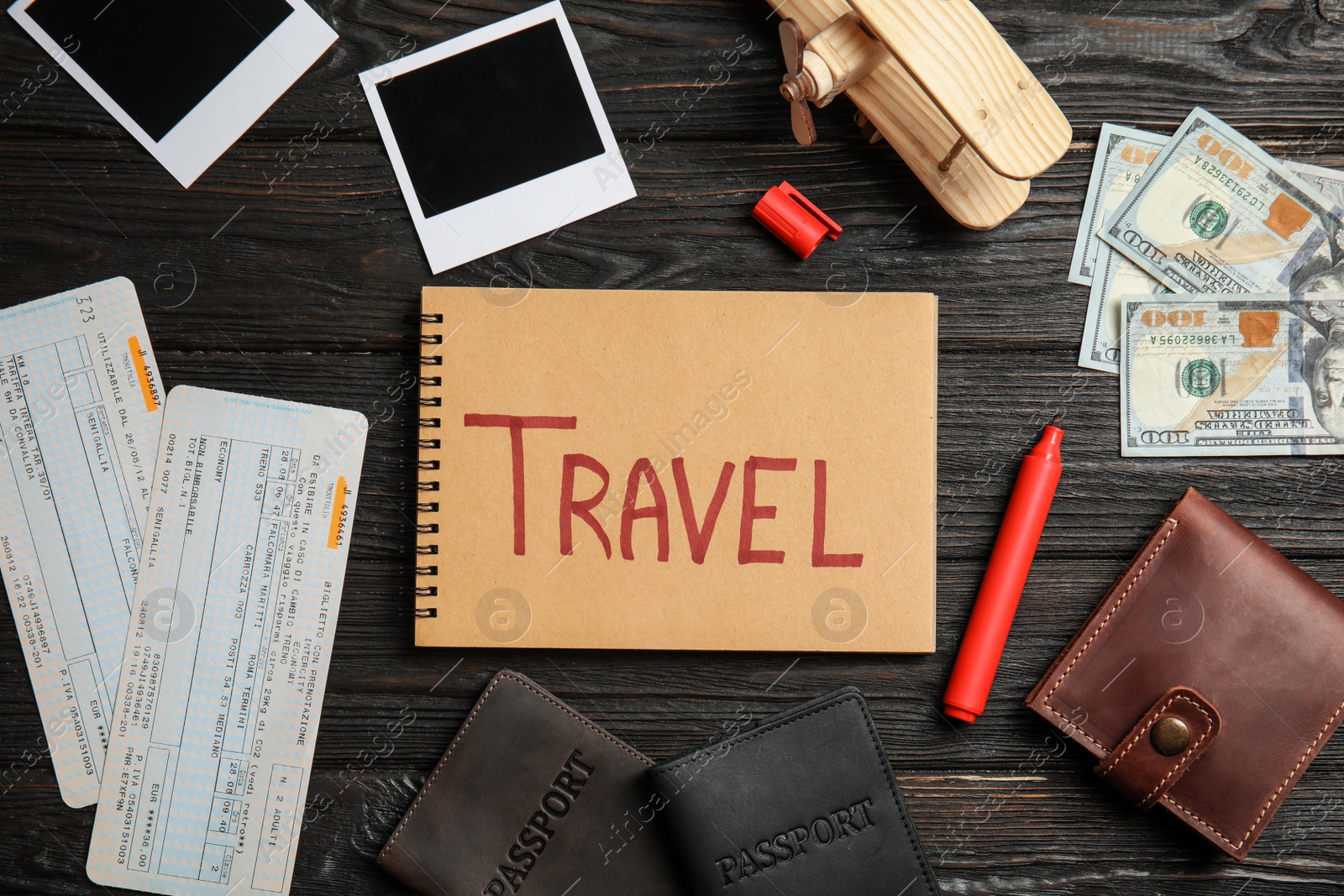 Photo of Flat lay composition with different tourist objects and word TRAVEL on wooden background