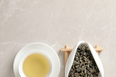 Photo of Cup of Tie Guan Yin oolong and chahe with tea leaves on table, top view. Space for text