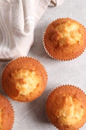 Photo of Tasty muffins on light grey table, flat lay. Fresh pastry