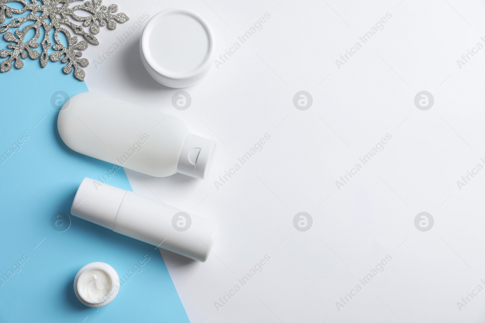 Photo of Set of cosmetic products on color background, flat lay with space for text. Winter care