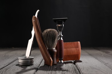 Photo of Moustache and beard styling tools on wooden table