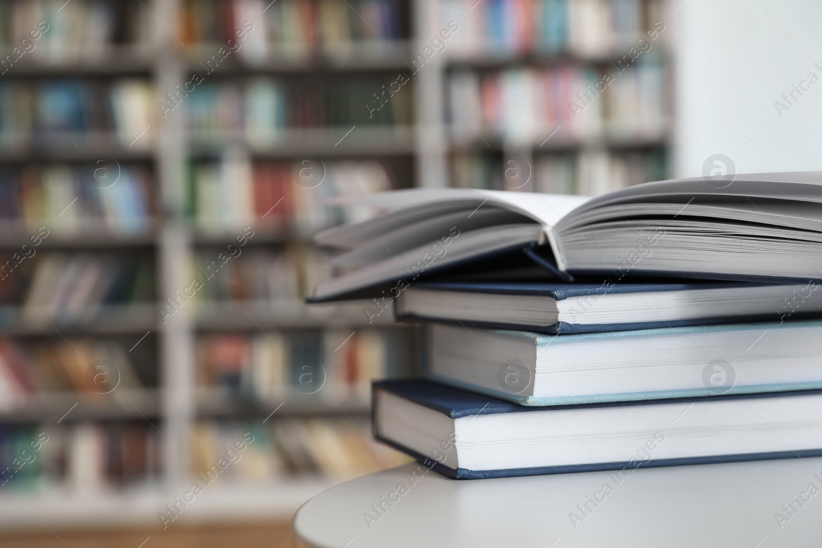 Photo of Stack of books on white table in library