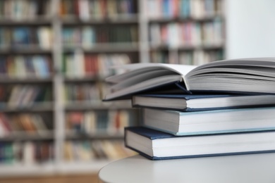 Stack of books on white table in library