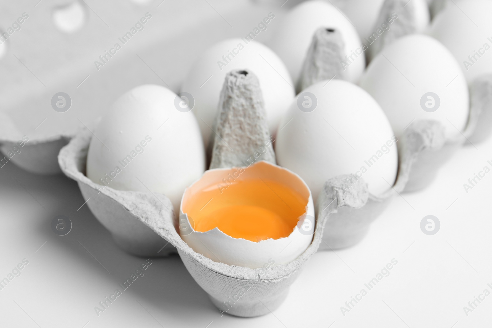 Photo of Fresh chicken eggs in box on white background, closeup