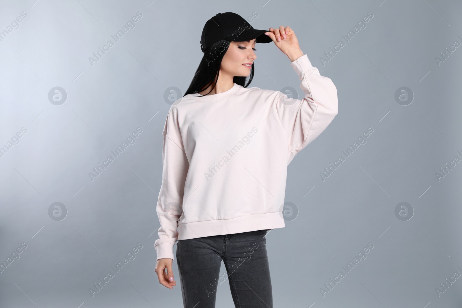 Photo of Portrait of young woman in sweater on grey background. Mock up for design