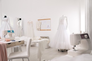 Photo of Dressmaking workshop interior with wedding dresses and equipment