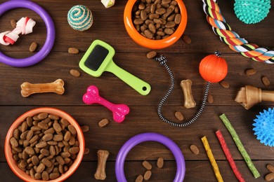 Photo of Flat lay composition with different pet goods on wooden background. Shop assortment