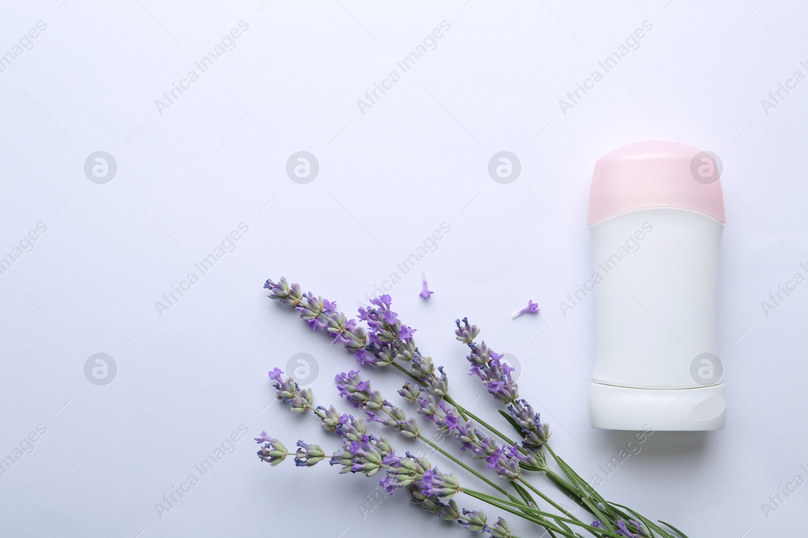 Photo of Female deodorant and lavender flowers on white background, top view