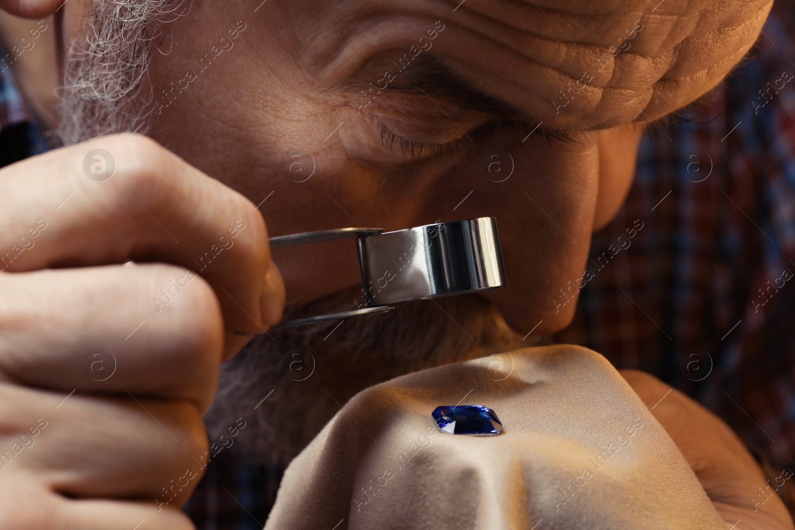 Photo of Professional jeweler working with gemstone, closeup view