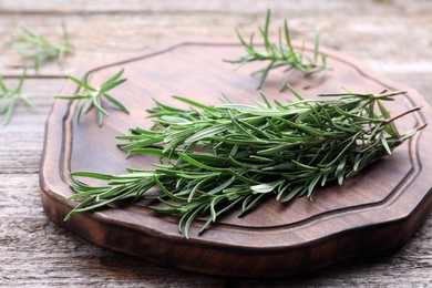 Photo of Sprigs of fresh rosemary on wooden table, closeup
