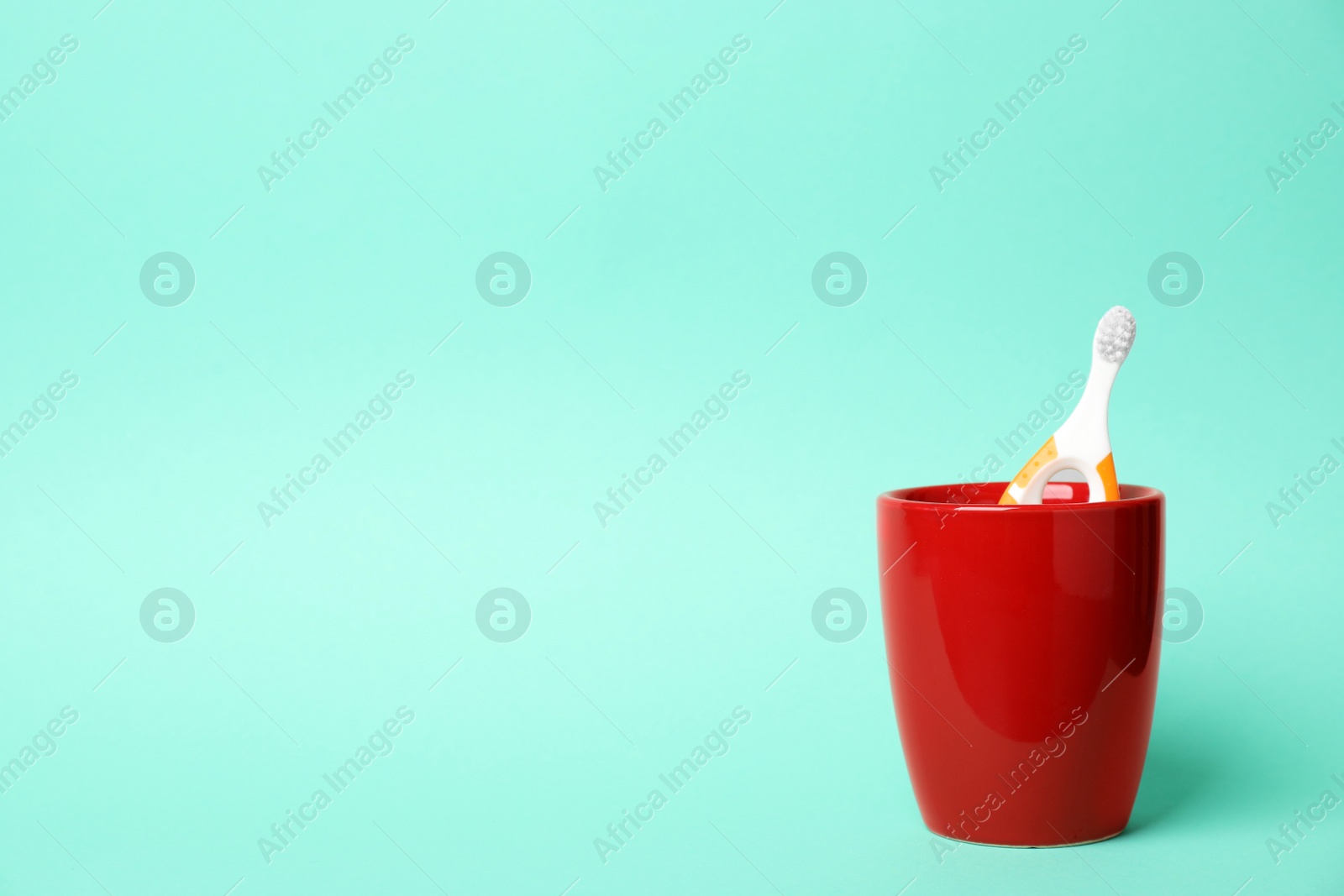 Photo of Baby toothbrush in holder and space for text on color background