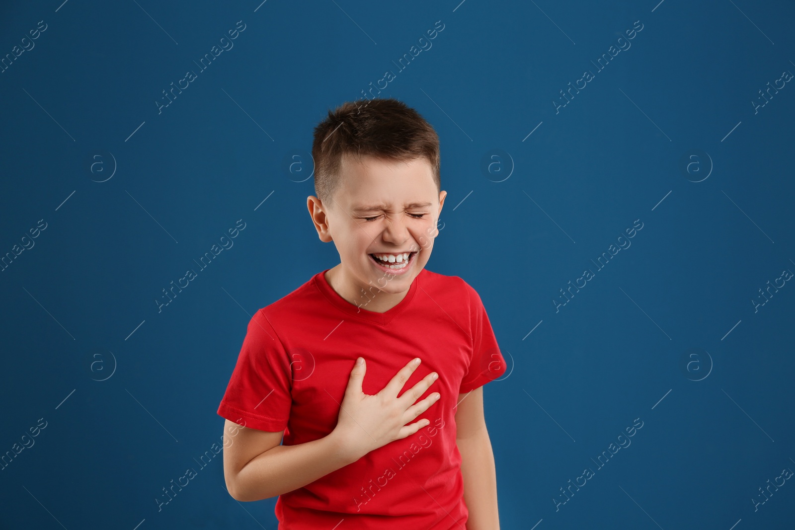 Photo of Portrait of emotional preteen boy on blue background