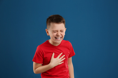 Portrait of emotional preteen boy on blue background